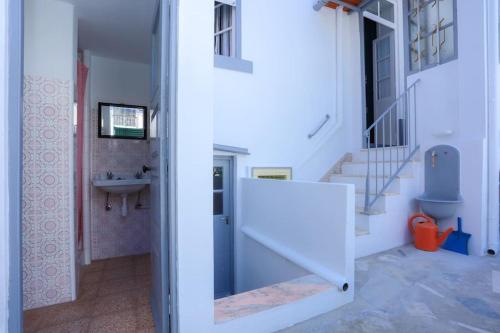 a bathroom with a sink and a staircase in a house at Patio da Foz - Appartement très accueillant centre-ville in Figueira da Foz