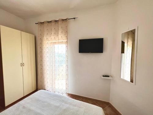 een slaapkamer met een bed en een televisie aan de muur bij Marì in Vico del Gargano