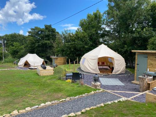 two tents are set up in a field at Glamping Red Wharf Bay in Pentraeth