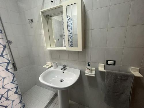 ein weißes Badezimmer mit einem Waschbecken und einem Spiegel in der Unterkunft Nespolilla in Petrosino