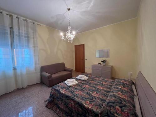ein Schlafzimmer mit einem Bett, einem Stuhl und einem Kronleuchter in der Unterkunft Nespolilla in Petrosino