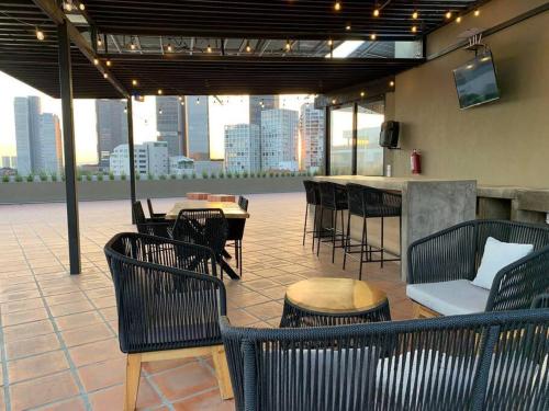 eine Terrasse mit Stühlen, einem Tisch und einer Bar in der Unterkunft Elegante en zona financiera / Limpieza diaria in Guadalajara