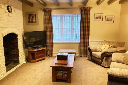 a living room with a couch and a tv at Station Lodge South in Nannerch