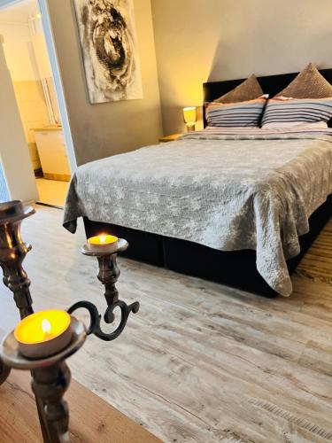 a bedroom with a bed and two candles in front of it at Zizi's House Gării 2 in Braşov