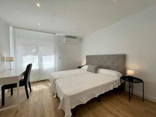 een slaapkamer met een bed, een tafel en een bureau bij VUT Correhuela in Salamanca