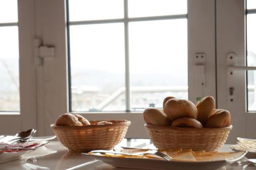 two baskets of bread on a table with windows at Terrassenhotel Seepromenade in Edersee