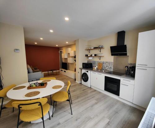 uma cozinha e sala de estar com mesa e cadeiras em Le Bellerade - Rez-de-chaussée tout confort em Dunkerque