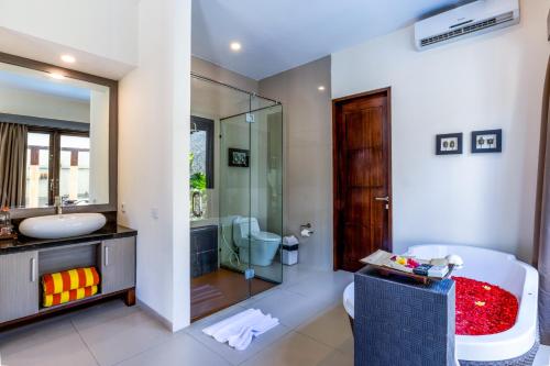 a bathroom with a tub and a sink and a shower at Luxotic Private Villa and Resort in Nusa Dua