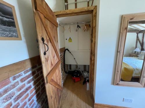 a door leading into a room with a bed at The Cow Shed 1BR-Sleeps4-Parking-PetsOK in Bradwell on Sea