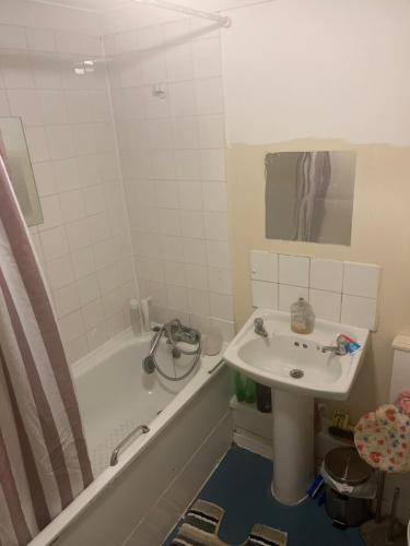 een badkamer met een wastafel, een bad en een wastafel bij The Croydon Road house in Elmers End