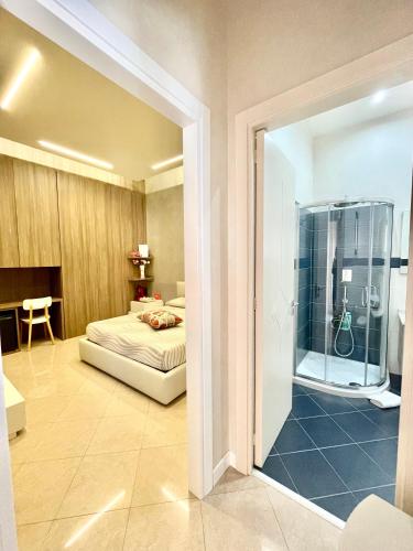 a bedroom with a bed and a glass shower at Luxury B&B Coccolhouse in San Cesario di Lecce
