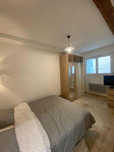 une chambre avec un lit dans une pièce avec une fenêtre dans l'établissement Charmant deux pièces dans le vieil Antibes Safranier, à Antibes