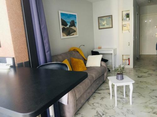 un salon avec un canapé et une table dans l'établissement Studio avec parking au calme 50m Croisette, à Cannes