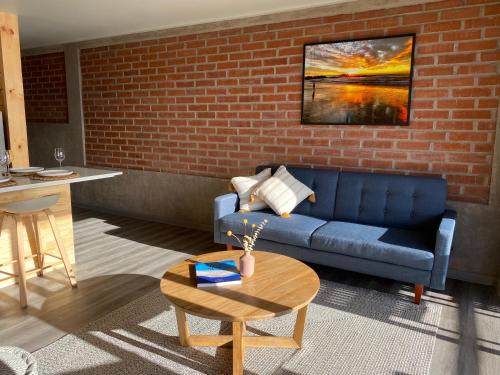 a living room with a blue couch and a brick wall at Cabañas La Matanza in Matanzas