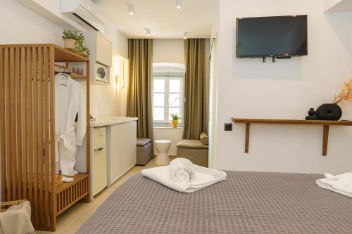 a bathroom with two beds and a television on the wall at La Vie Hydra Luxury Suites in Hydra