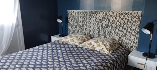 um quarto com uma cama com cabeceira e almofadas em Joli appartement avec grande et belle terrasse, au pied de la plage du Grazel! em Gruissan