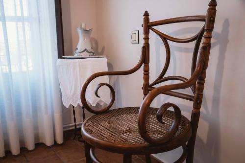 a wooden chair sitting in a room with a curtain at El Requexu, apartamentos a 900 m de la playa de Poo AR-0474-AS in Llanes