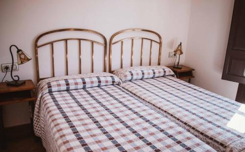 a bedroom with two beds and two lamps on tables at El Requexu, apartamentos a 900 m de la playa de Poo AR-0474-AS in Llanes