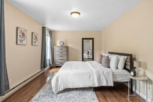a bedroom with a large white bed and a mirror at Serene Escape In Finger Lakes Wine Country Close to Ithaca in Lansing