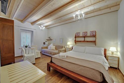 a bedroom with a large bed and a living room at B&B Villa Rossella con piscina in Castelnuovo del Garda