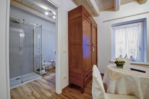 a bathroom with a shower and a table and a cabinet at B&B Villa Rossella con piscina in Castelnuovo del Garda