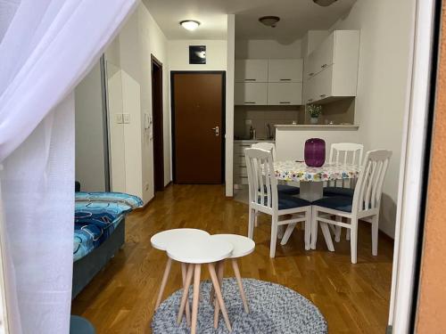 sala de estar con mesa y sillas y cocina en Lovely apartment with the parking place, en Podgorica