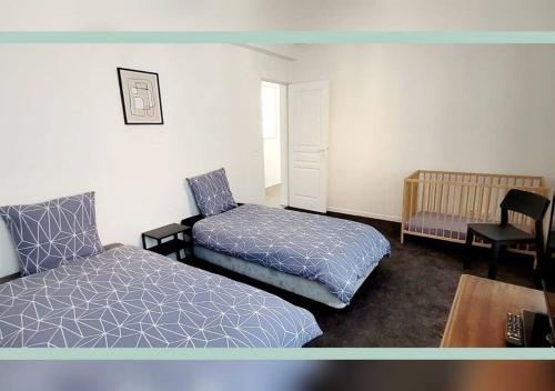 1 dormitorio con 1 cama, 1 silla y 1 mesa en Spacieux T3 au pied des Thermes, en Néris-les-Bains
