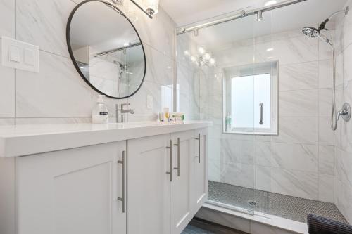 a white bathroom with a mirror and a shower at Luxe Lodges on Lake Erie in Port Dover