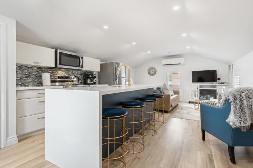 a kitchen with white cabinets and bar stools at Luxe Lodges on Lake Erie in Port Dover