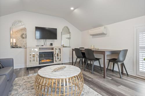a living room with a table and a fireplace at Luxe Lodges on Lake Erie in Port Dover