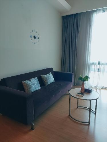 a living room with a blue couch and a table at Swiss Garden Residence affordable stay in Kuala Lumpur