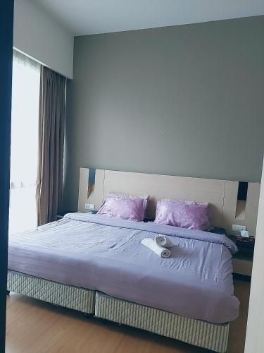 a bedroom with a bed with purple sheets and a window at Swiss Garden Residence affordable stay in Kuala Lumpur