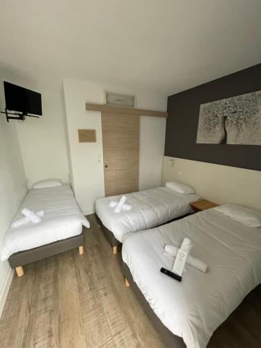 a hotel room with two beds and a tv at Europe Hotel in Beaurepaire-en-Bresse