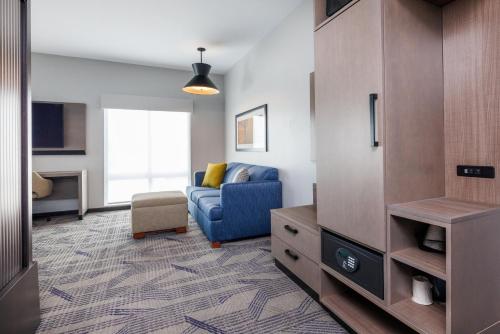 a living room with a blue couch and a chair at Hyatt Place San Carlos in San Carlos
