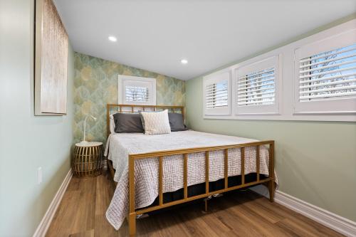 ein Schlafzimmer mit einem Bett und zwei Fenstern in der Unterkunft Luxe Lodges on Lake Erie in Port Dover