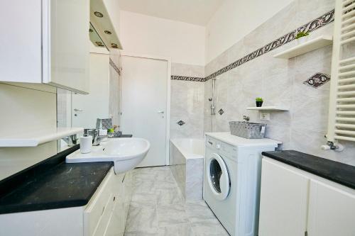 uma casa de banho branca com um lavatório e uma máquina de lavar roupa em Luna em Buccinasco