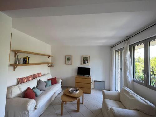 a white living room with a couch and a table at Appartement avec jardin au coeur de Saint-Tropez. in Saint-Tropez