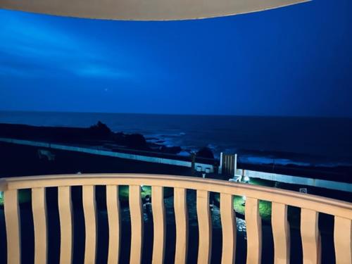 a view of the ocean at night from a bench at Apartamento Oceano in Barreiros