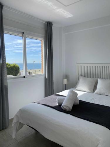 ein Schlafzimmer mit einem großen Bett mit einem großen Fenster in der Unterkunft Apartamento 2 habitaciones frontal al mar 3 in Torre del Mar