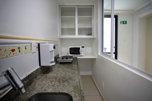 a small kitchen with a sink and a microwave at Maceió Atlantic Suites in Maceió