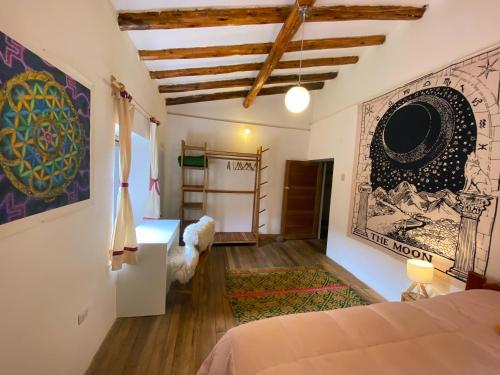 ピサックにあるSonqo Andino Hospedaje Medicinaのベッドと壁に絵が飾られた寝室