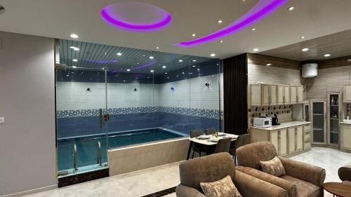 een badkamer met een bad en een zwembad bij شاليهات و فلل عائلية بمسابح خاصة in Khamis Mushayt