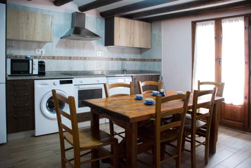 een keuken met een houten tafel en stoelen bij Casa Barranquero in Riglos
