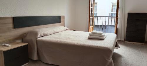 Maravilloso piso de dos dormitorios en Huéscar في هويسكار: غرفة نوم عليها سرير وفوط