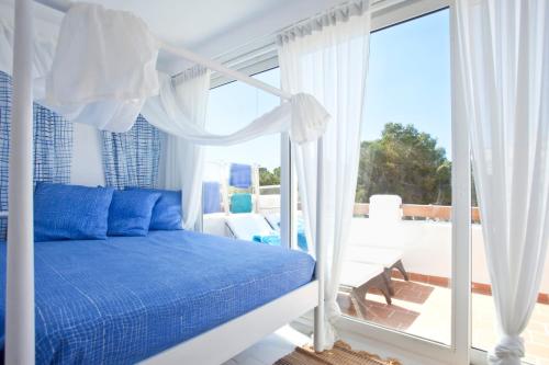 a bedroom with a blue bed and a balcony at Bungalow Playa dOr 4 in Cala d´Or