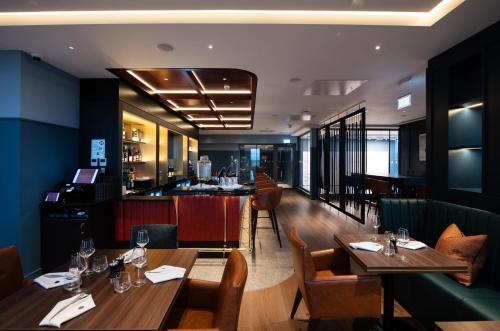 un restaurante con mesas de madera y un bar en The Landing Hotel, en Westerham