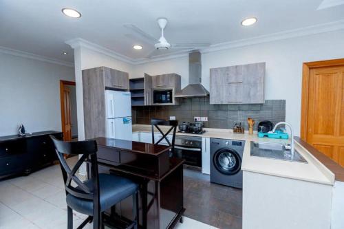 a kitchen with a sink and a dishwasher at Colosseum Square Luxury Apartments in Dar es Salaam