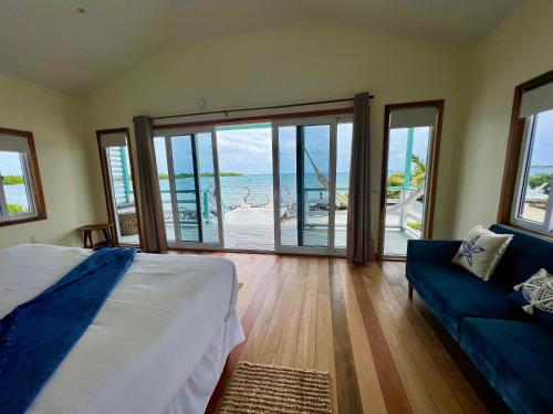 a bedroom with a bed and a view of the beach at Blue Reef Island in Dangriga