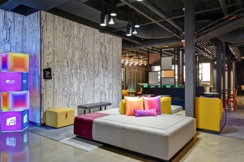 a room with a bed and some colorful furniture at Aloft Secaucus Meadowlands in Secaucus