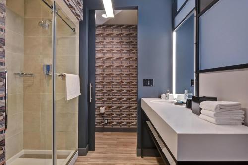 a bathroom with a sink and a glass shower at Aloft Secaucus Meadowlands in Secaucus